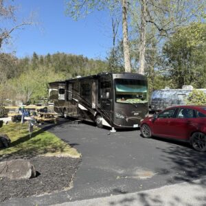 Class A Motorhome and car in Deluxe Creekside Site at Outdoor Resorts at Gatlinburg