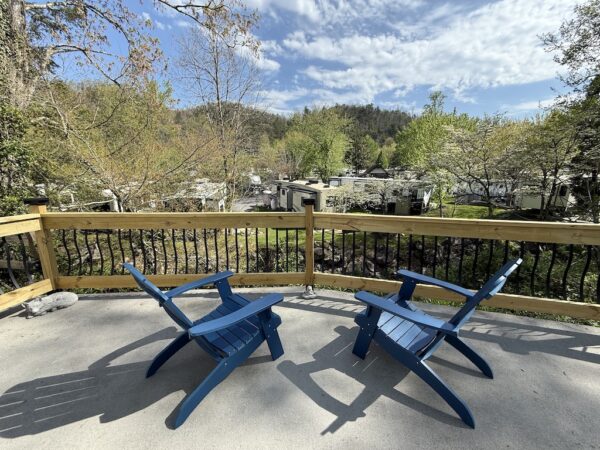 Blue adirondack chairs on patio by fence creekside lot overlooking resort Outdoor Resorts at Gatlinburg