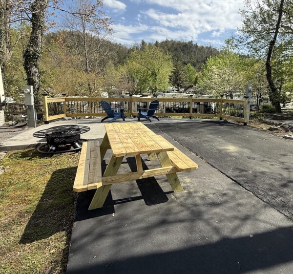 Picnic table, firepit, blue adirondack chairs on creekside lot Outdoor Resorts at Gatlinburg