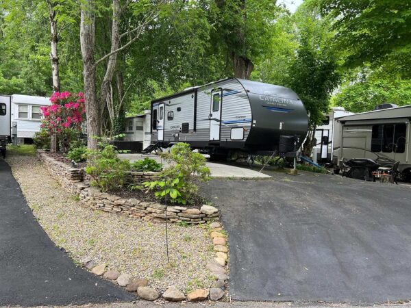 Deluxe Hillside site with landscaping, paved lot, and concrete patio